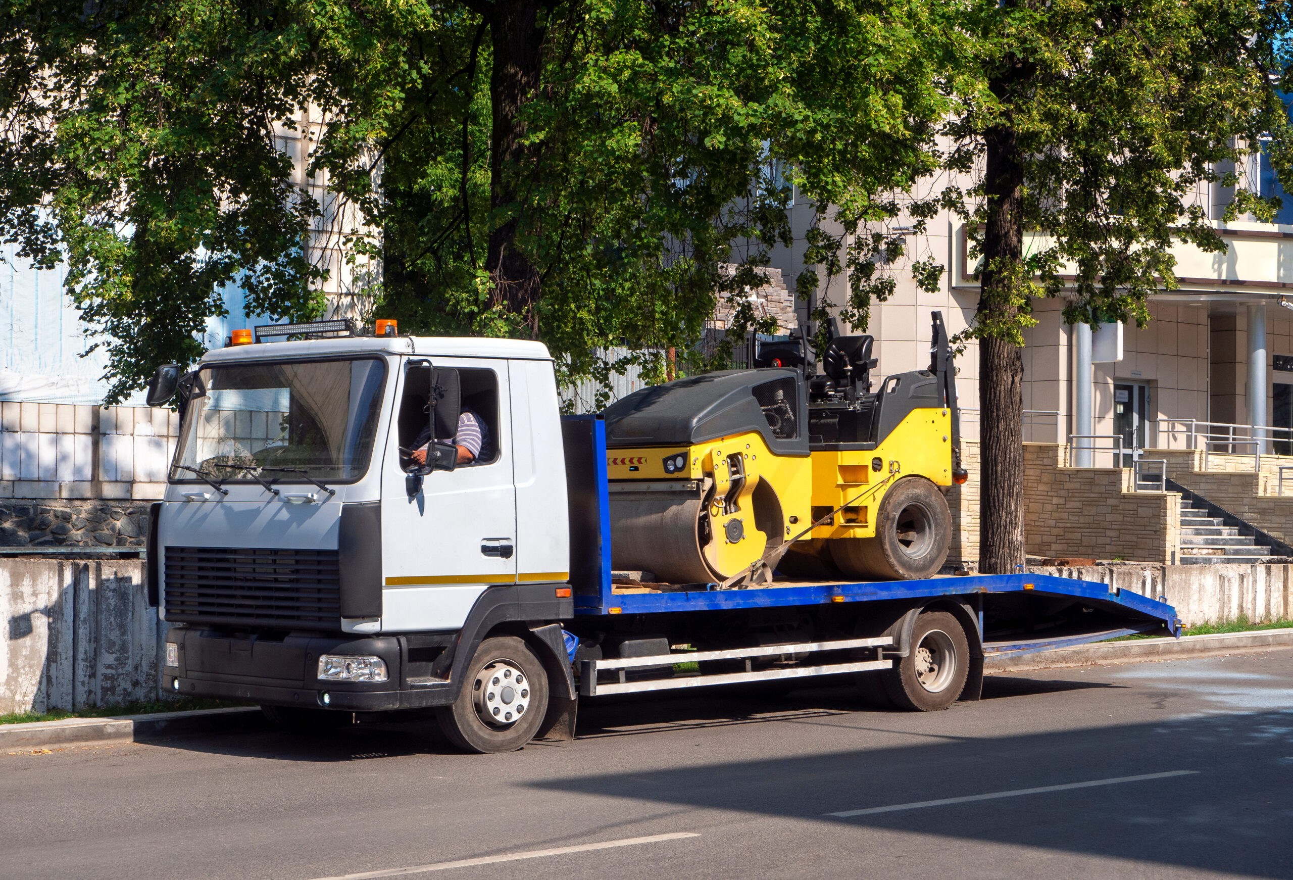 A,Tow,Truck,Transports,The,Road,Roller,On,A,Stationary